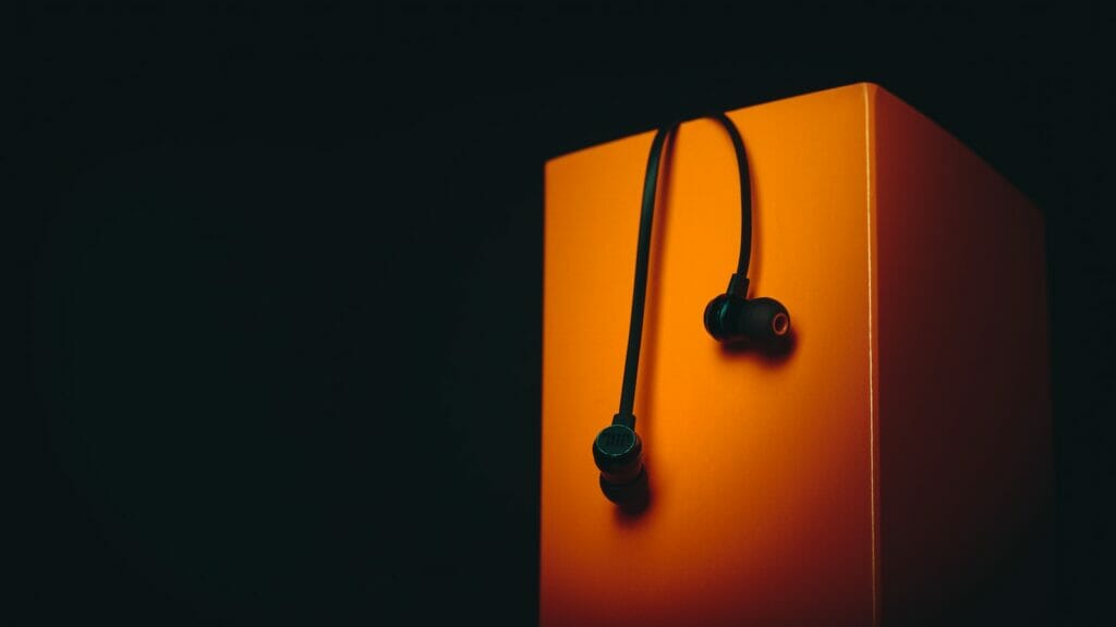 a pair of ear buds sitting on top of an orange box
