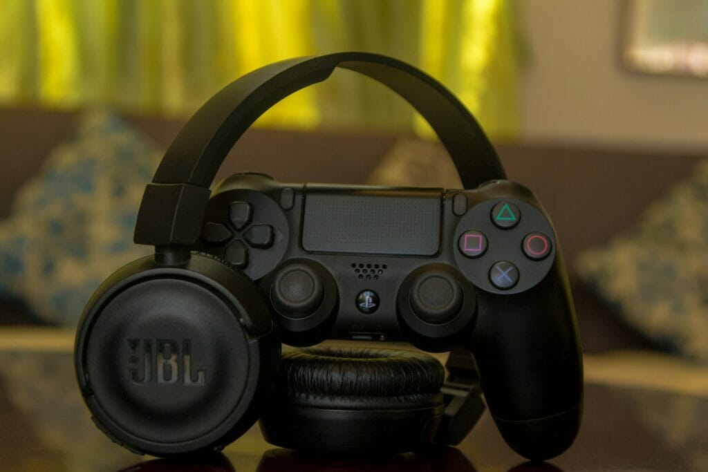 black Sony PS4 controller and JBL headphones