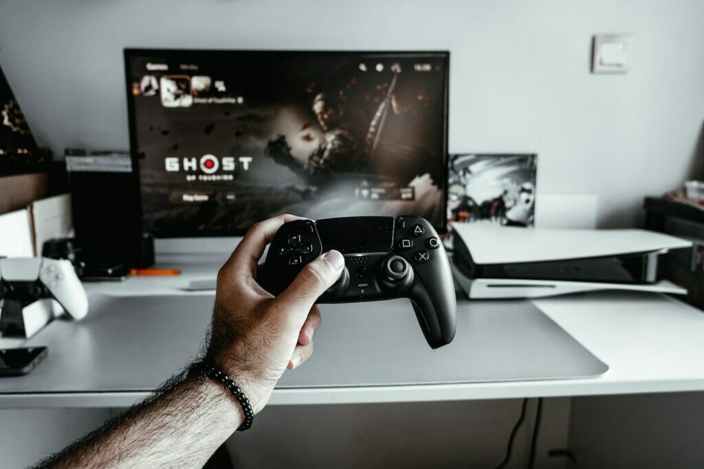 a person holding a video game controller in front of a tv