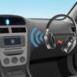 A car interior showing a dashboard with a stereo system and a pair of Bluetooth headphones nearby, indicating a failed connection between them.