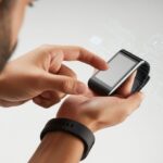 A hand touching the screen of a fitness tracker that appears unresponsive.
