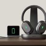 How to Tell if Bluetooth Headphones Are Fully Charged: No More Power Outage Surprises A pair of Bluetooth headphones on a charging dock with green LED lights indicating full charge and a nearby screen showing a full battery icon.
