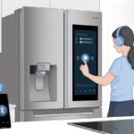 Person wearing Bluetooth headphones using a smart refrigerator with a touchscreen in a kitchen.