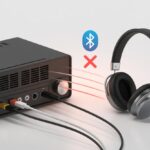 A pair of Bluetooth headphones near an amplifier with a red X symbol between them indicating they are not connecting.