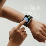 How to Send Texts from a Smartwatch Without Looking Like a Secret Agent Close-up of a person tapping a smartwatch screen on their wrist, showing a messaging app interface with floating message icons around it.