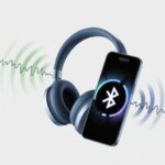 Bluetooth headphones and a smartphone showing fluctuating wireless connection signals indicating pairing and unpairing.