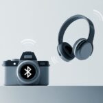 How to Use Bluetooth Headphones with a Camera So You Don’t Trip Over Cables (Again) A digital camera wirelessly connected to Bluetooth headphones with signal waves between them.