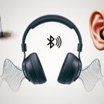 Why do my Bluetooth headphones sound muffled? Solving the Mystery of Underwater Pop Songs A pair of Bluetooth headphones with distorted sound waves and visual hints of dust, weak signal, and earwax blockage around them.