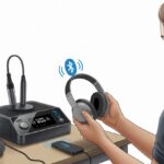 How to use Bluetooth headphones with a karaoke machine and actually hear yourself sing better than your shower does A person connecting Bluetooth headphones to a karaoke machine on a table, showing wireless connection signals and a microphone nearby.